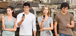 Full length of young men and women holding cellphone